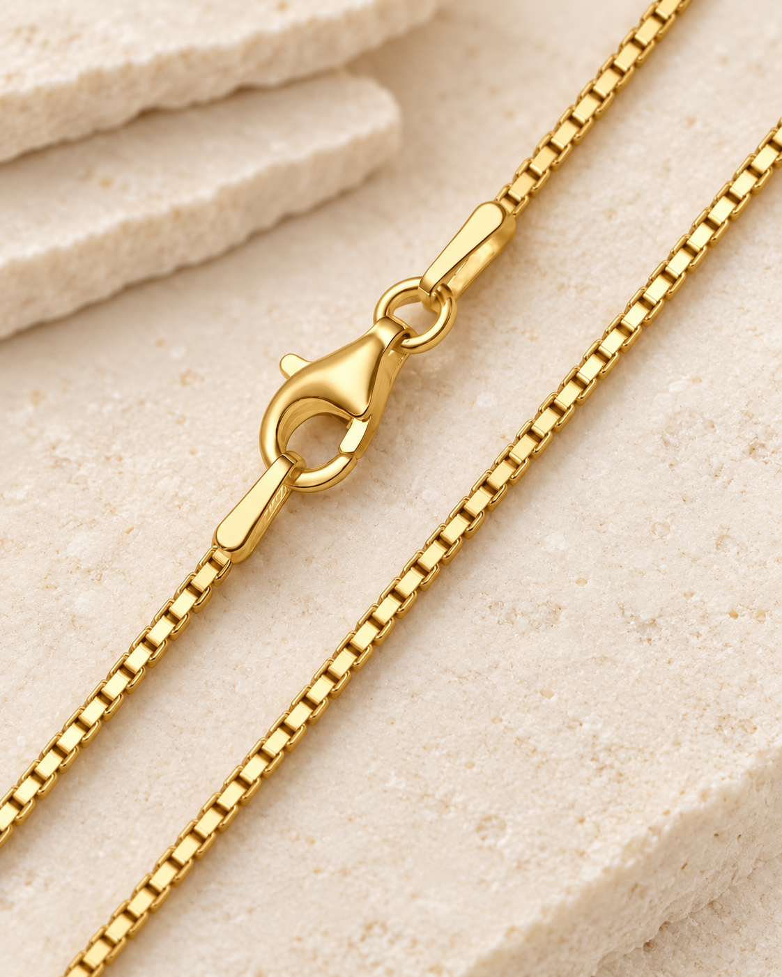 30 inch gold premium box chain with lobster clasp on cream stone.
