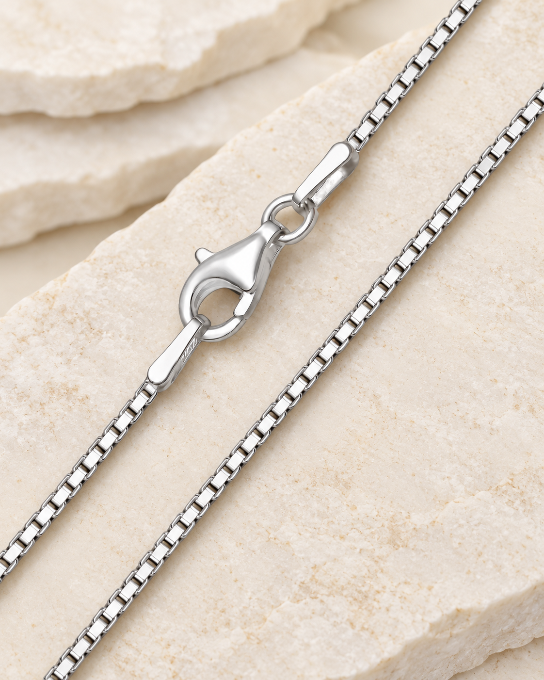 30 inch silver premium box chain with lobster clasp on cream stone.
