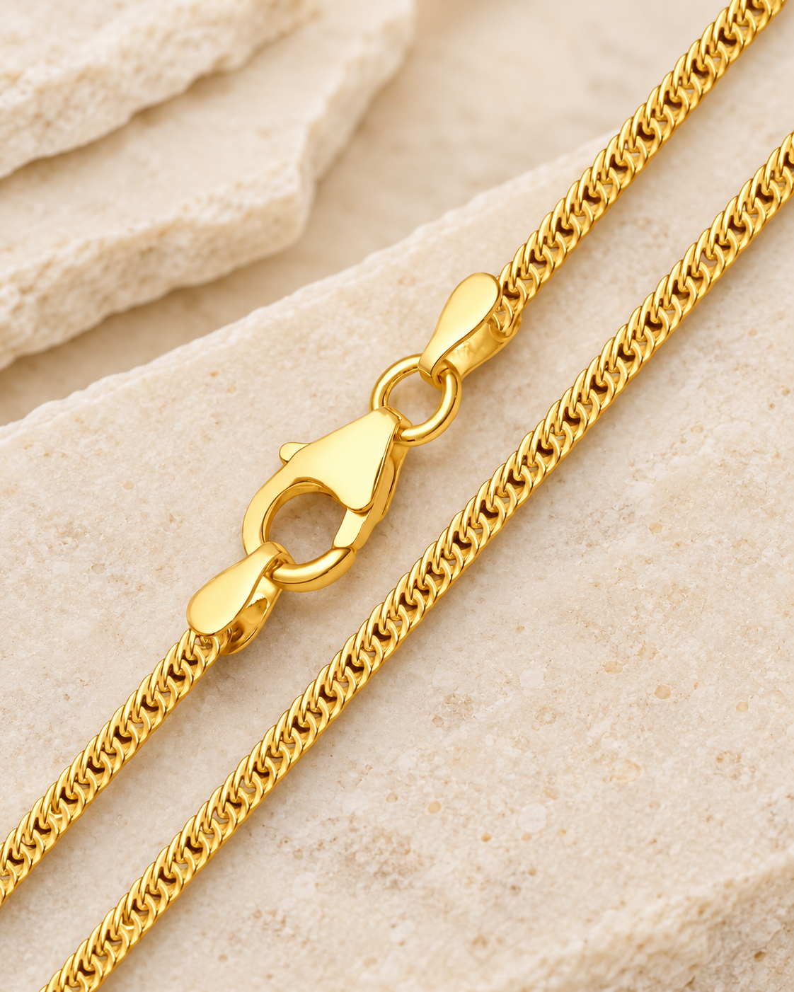 28 inch gold premium men's curb chain with lobster clasp on cream stone.