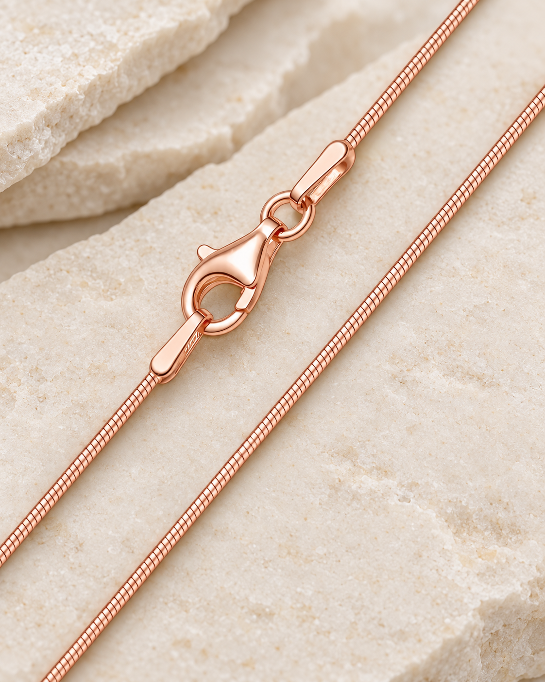 30 inch rose gold premium snake chain with lobster clasp on cream stone.