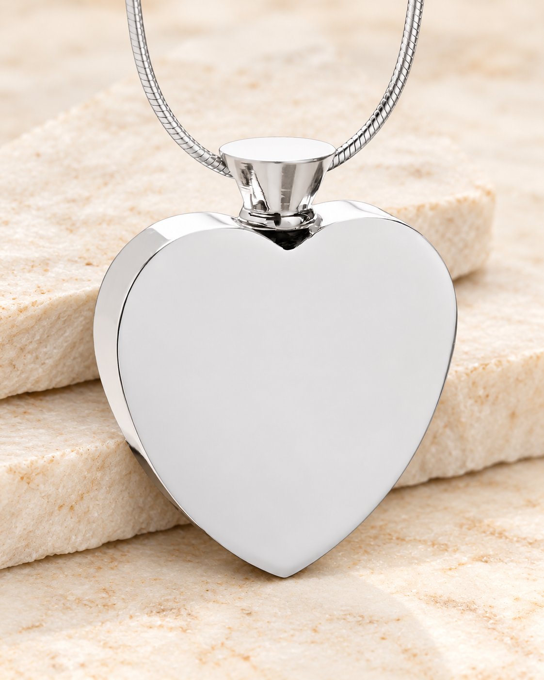 Stainless Steel Everlasting Journey Urn Pendant on a cream stacked-stone background