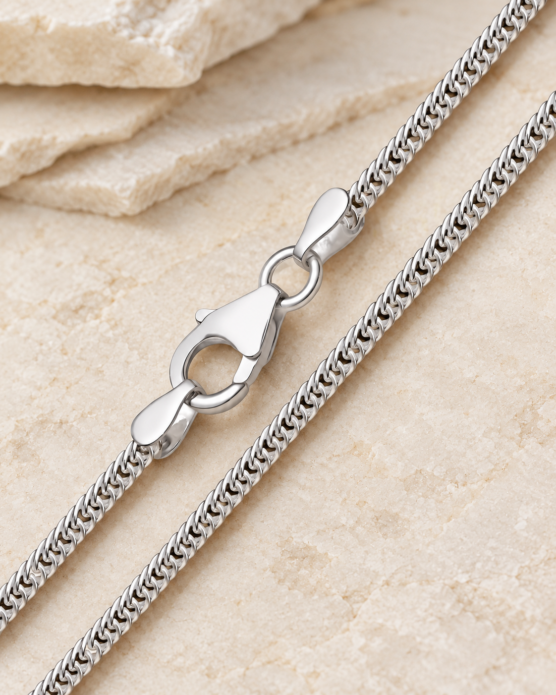 28 inch silver premium men's curb chain with lobster clasp on cream stone.