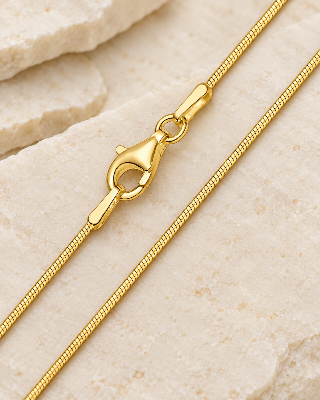 30 inch gold premium snake chain with lobster clasp on cream stone.