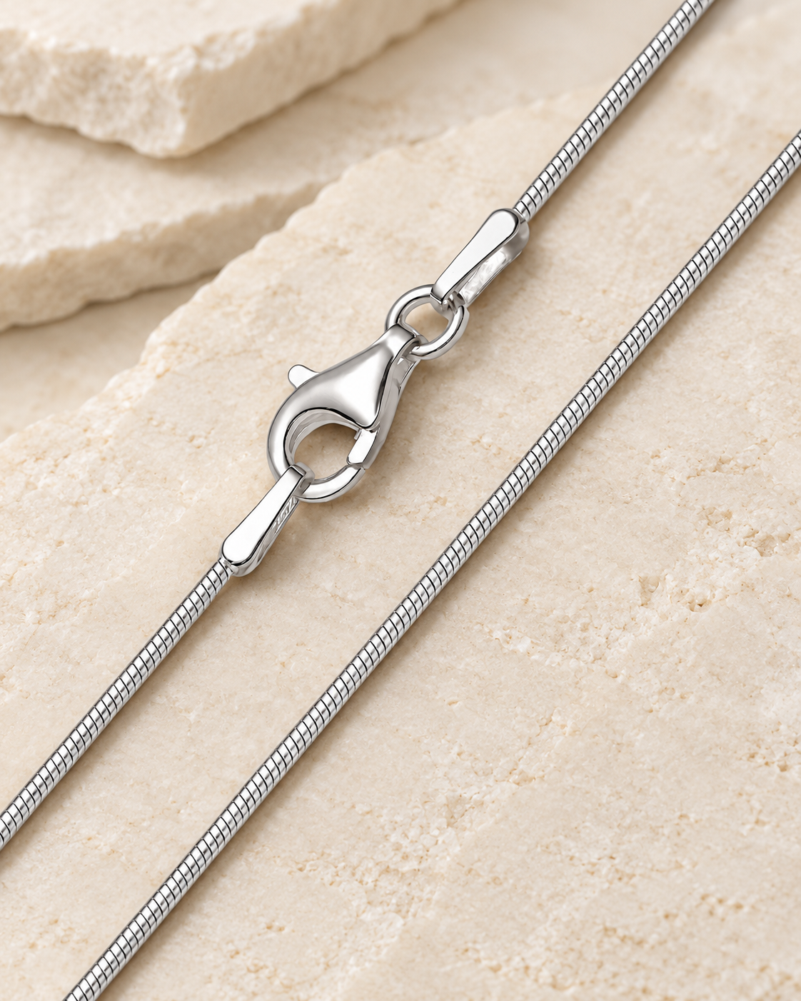 30 inch silver premium snake chain with lobster clasp on cream stone.